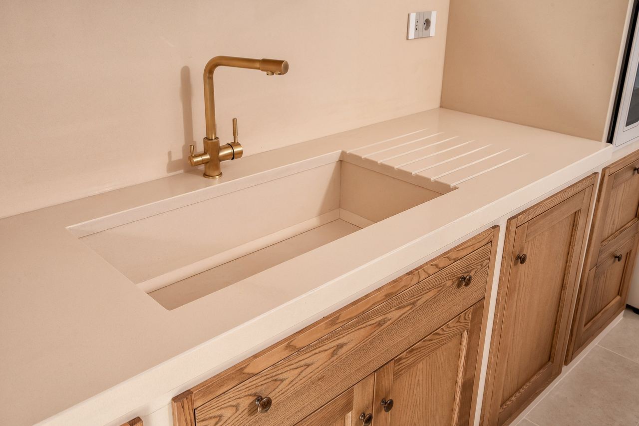Vasca e piano nella stessa lastra beige, con lo scolatoio inciso nel piano